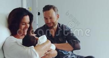 高加索夫妇在医院病房里抱着新生婴儿的正面景色